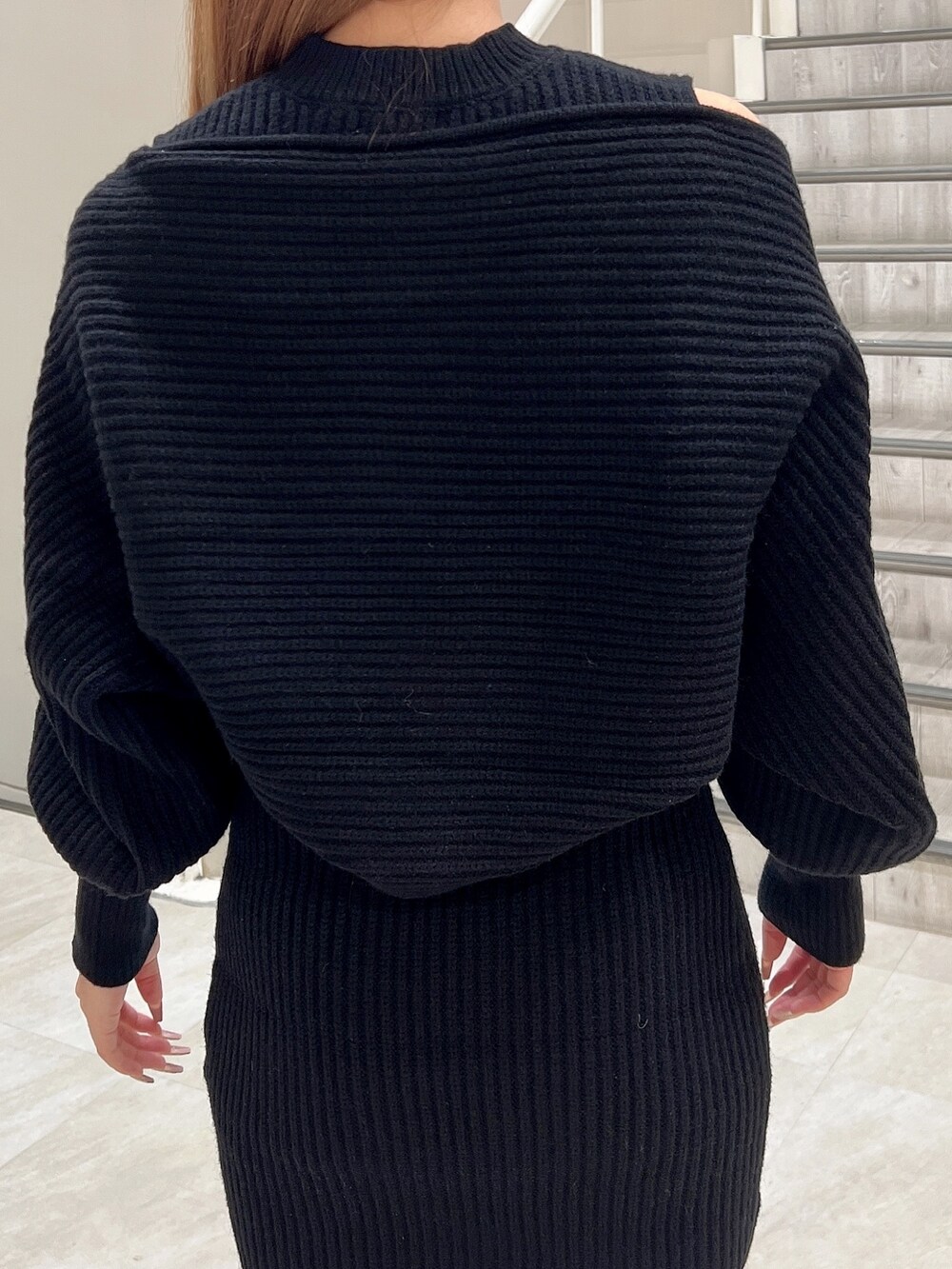 ブラック系のワンピース、ブラック系のブーツ、ブラック系のハンドバッグを着用したレディースの秋コーディネートの6枚目の写真