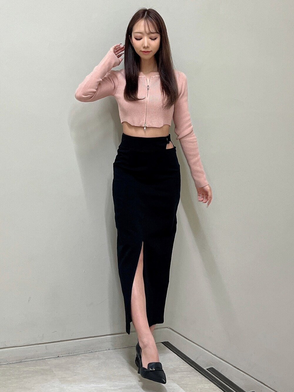 ブラック系のスカート、ピンク系のニット/セーター、ブラック系のパンプスを着用したレディースの冬コーディネートの3枚目の写真