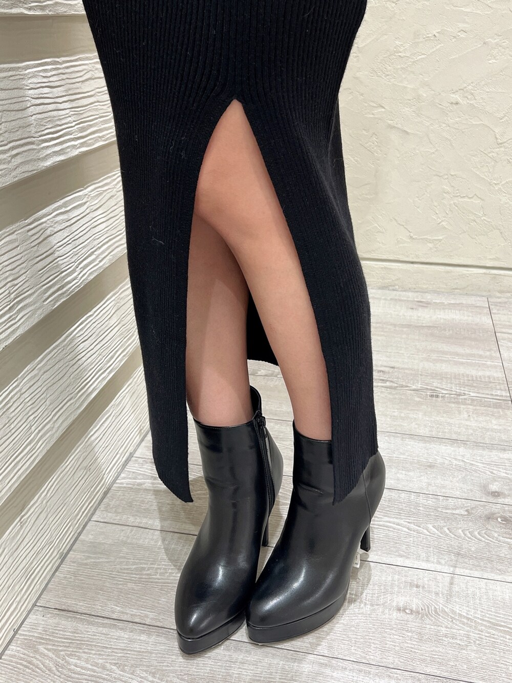 ブラック系のワンピース、ブラック系のブーツ、ホワイト系のブルゾンを着用したレディースの秋コーディネートの5枚目の写真