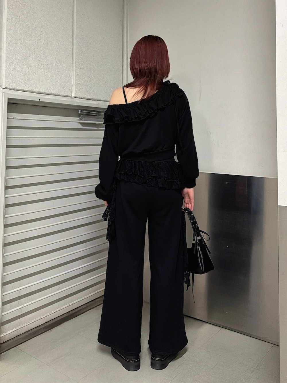 ブラック系のスウェットパンツ、ブラック系のハンドバッグ、ブラック系のスウェットを着用したレディースの冬コーディネートの3枚目の写真