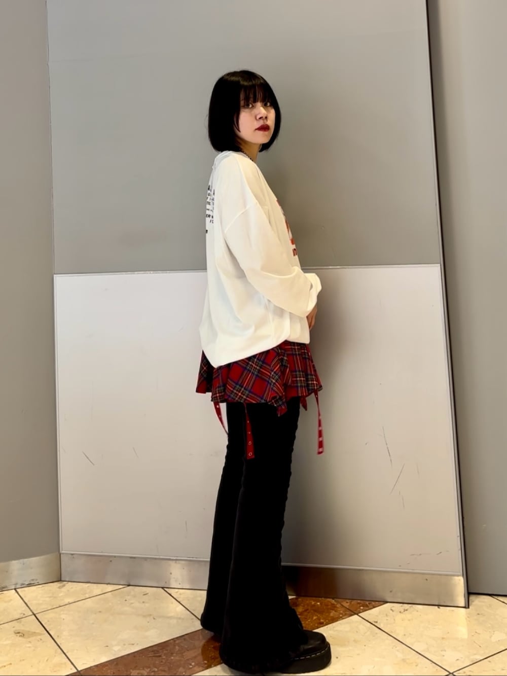 ブラック系のデニムパンツ、レッド系のスカート、ホワイト系のTシャツ/カットソーを着用したレディースの秋コーディネートの4枚目の写真