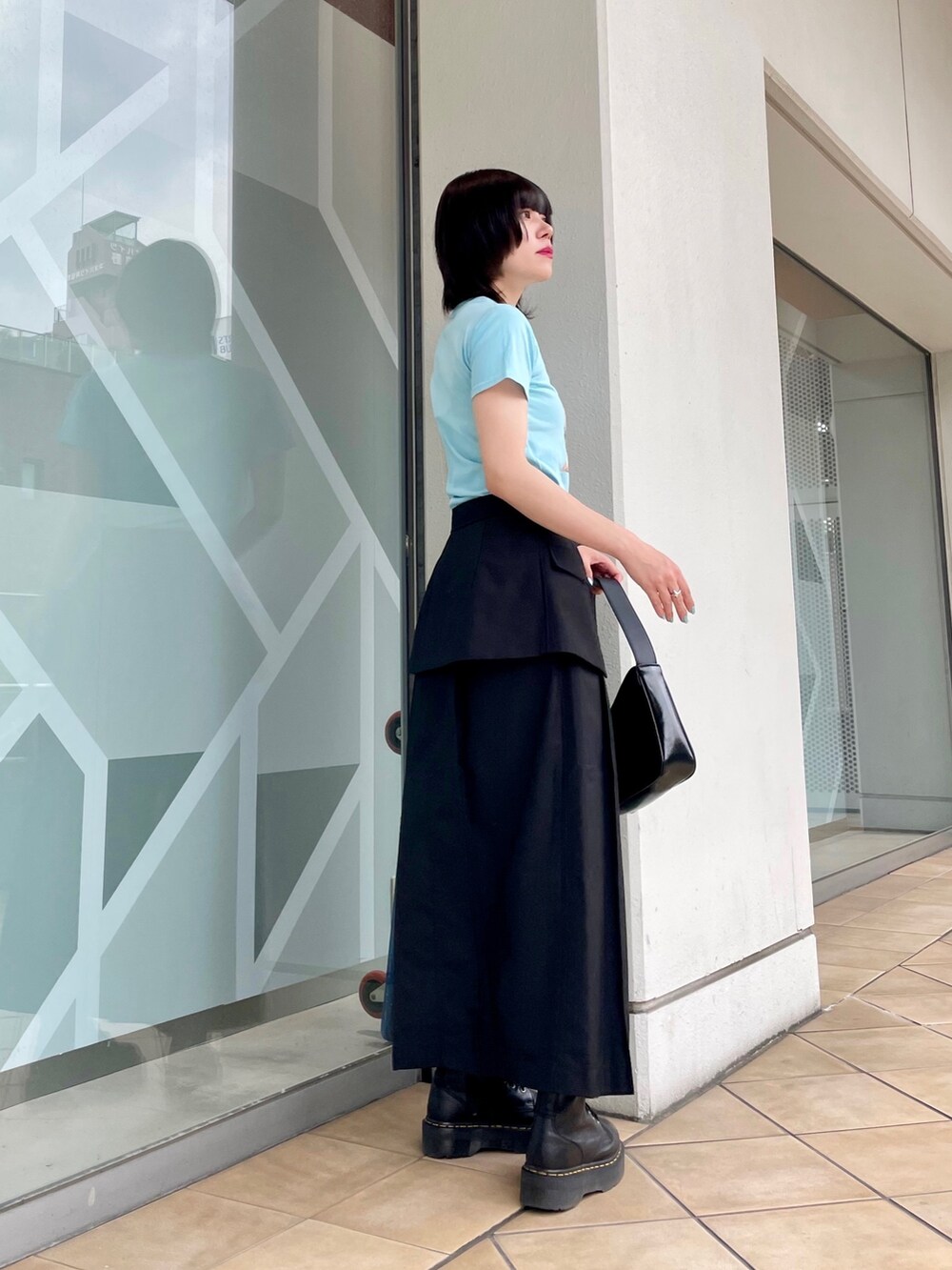 ブルー系のTシャツ/カットソー、ブラック系のスカート、シルバー系のハンドバッグを着用したレディースの春コーディネートの2枚目の写真