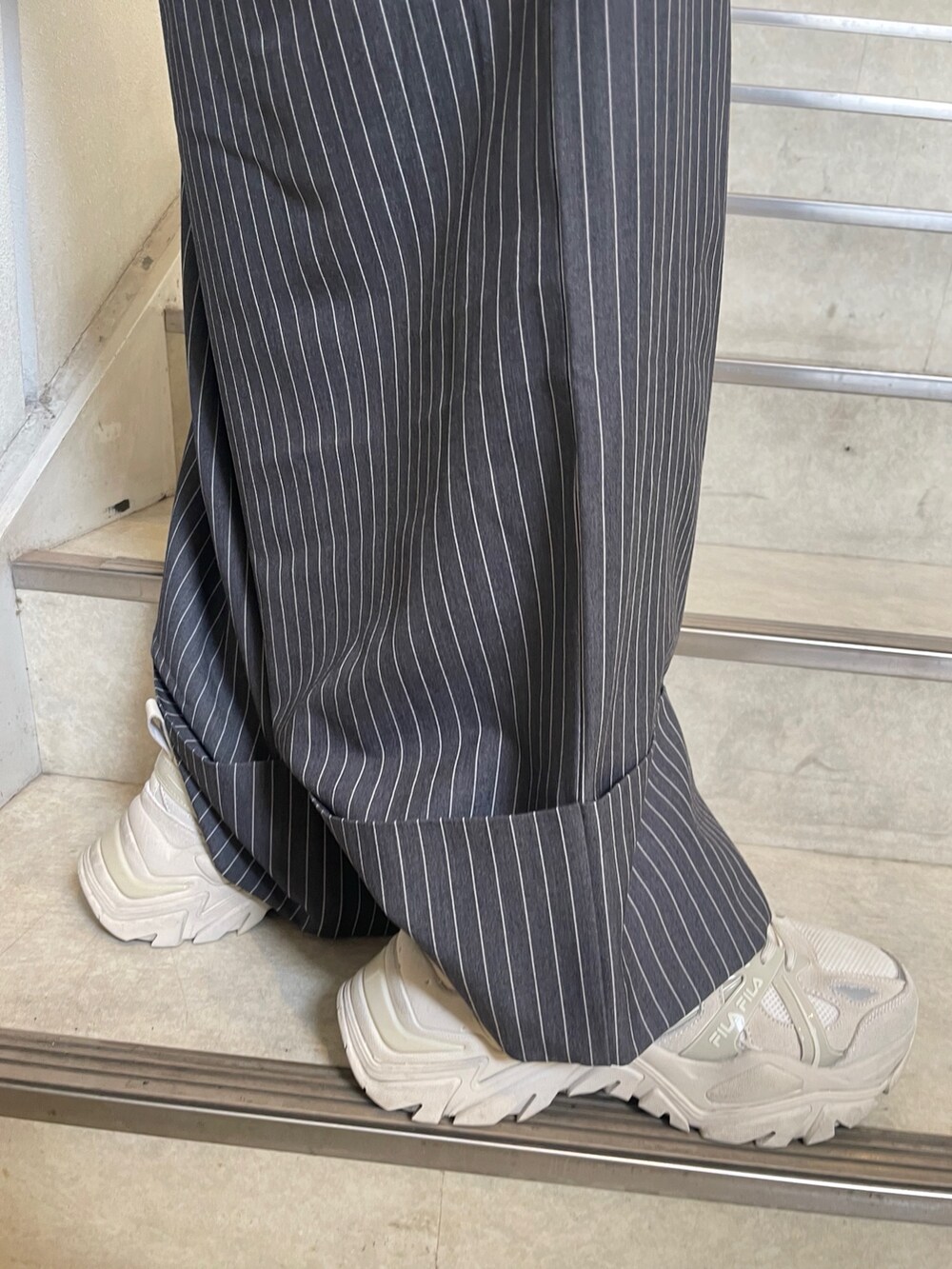 グレー系のつなぎ/オールインワン、ホワイト系のスニーカー、ベージュ系のTシャツ/カットソーを着用したレディースの冬コーディネートの9枚目の写真