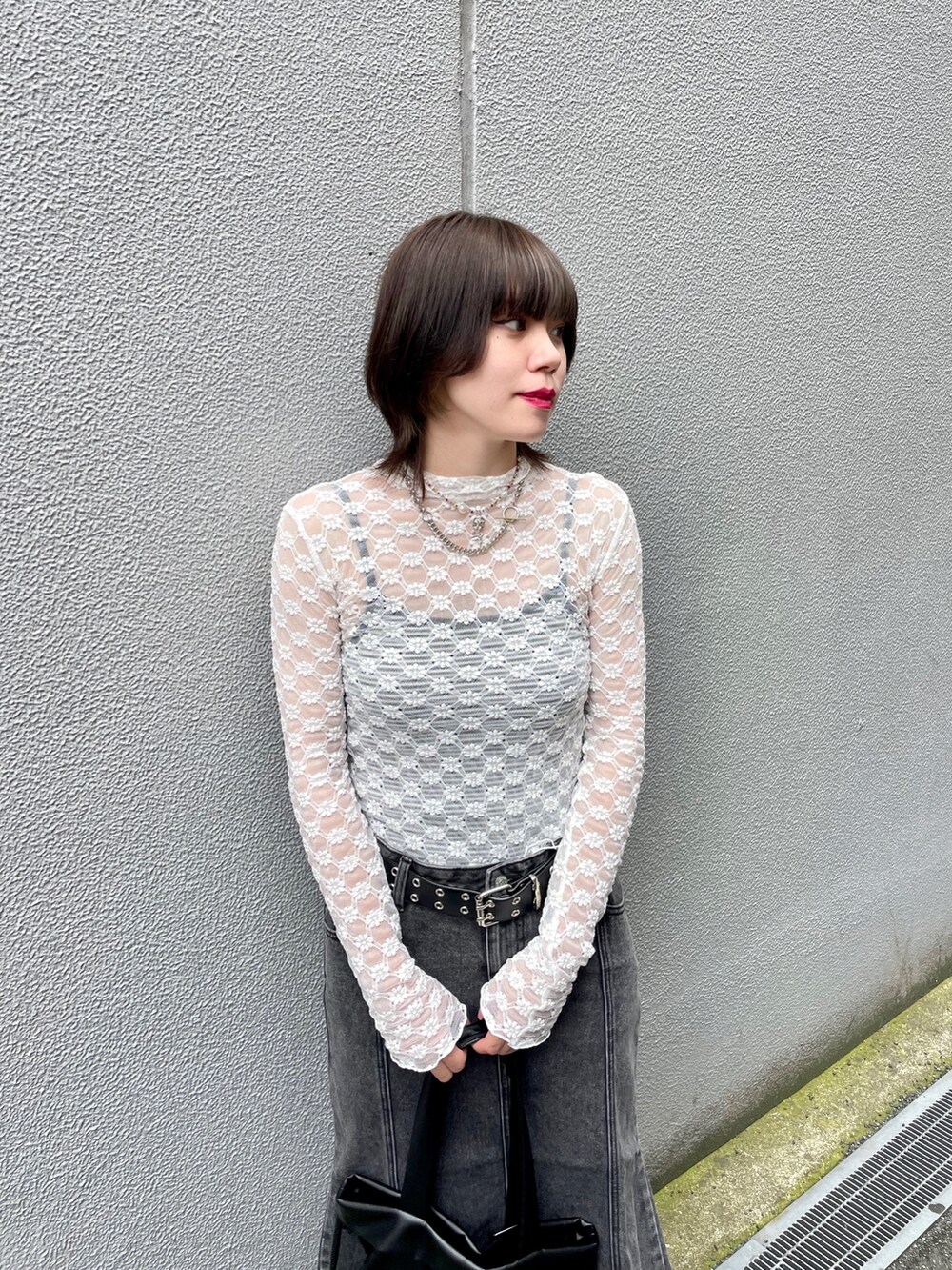 ホワイト系のTシャツ/カットソー、ブラック系のバックパック/リュック、ブラック系のデニムスカートを着用したレディースの夏コーディネートの7枚目の写真