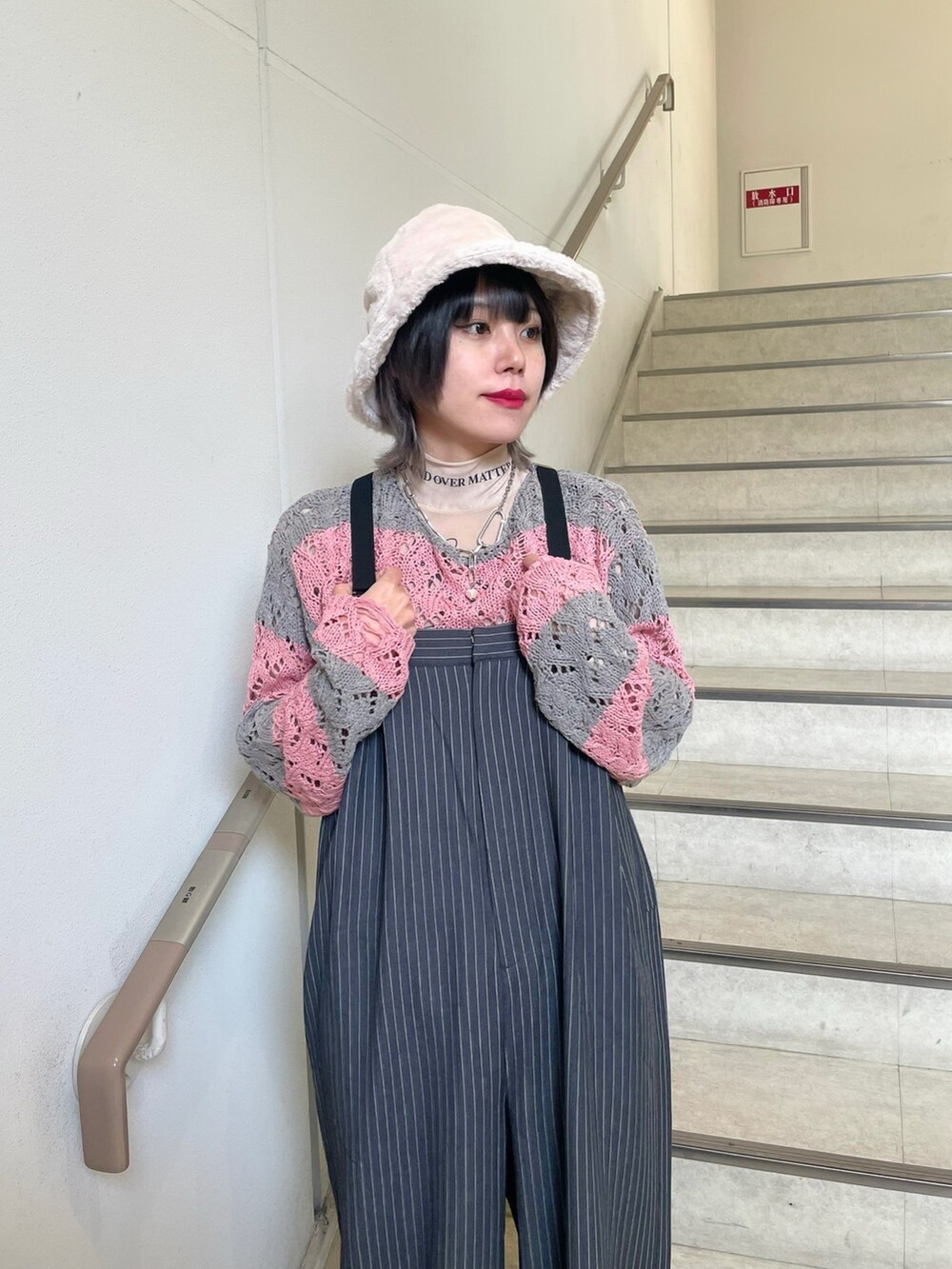 グレー系のつなぎ/オールインワン、ホワイト系のスニーカー、ベージュ系のTシャツ/カットソーを着用したレディースの冬コーディネートの5枚目の写真