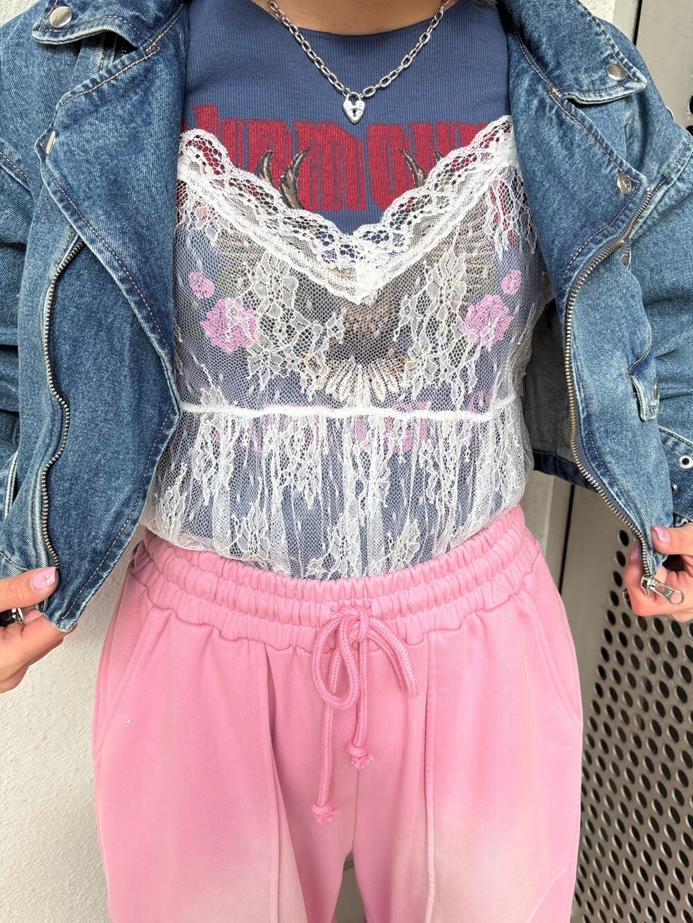 ホワイト系のスニーカー、ピンク系のスウェットパンツ、ブルー系のライダースジャケットを着用したレディースの春コーディネートの8枚目の写真