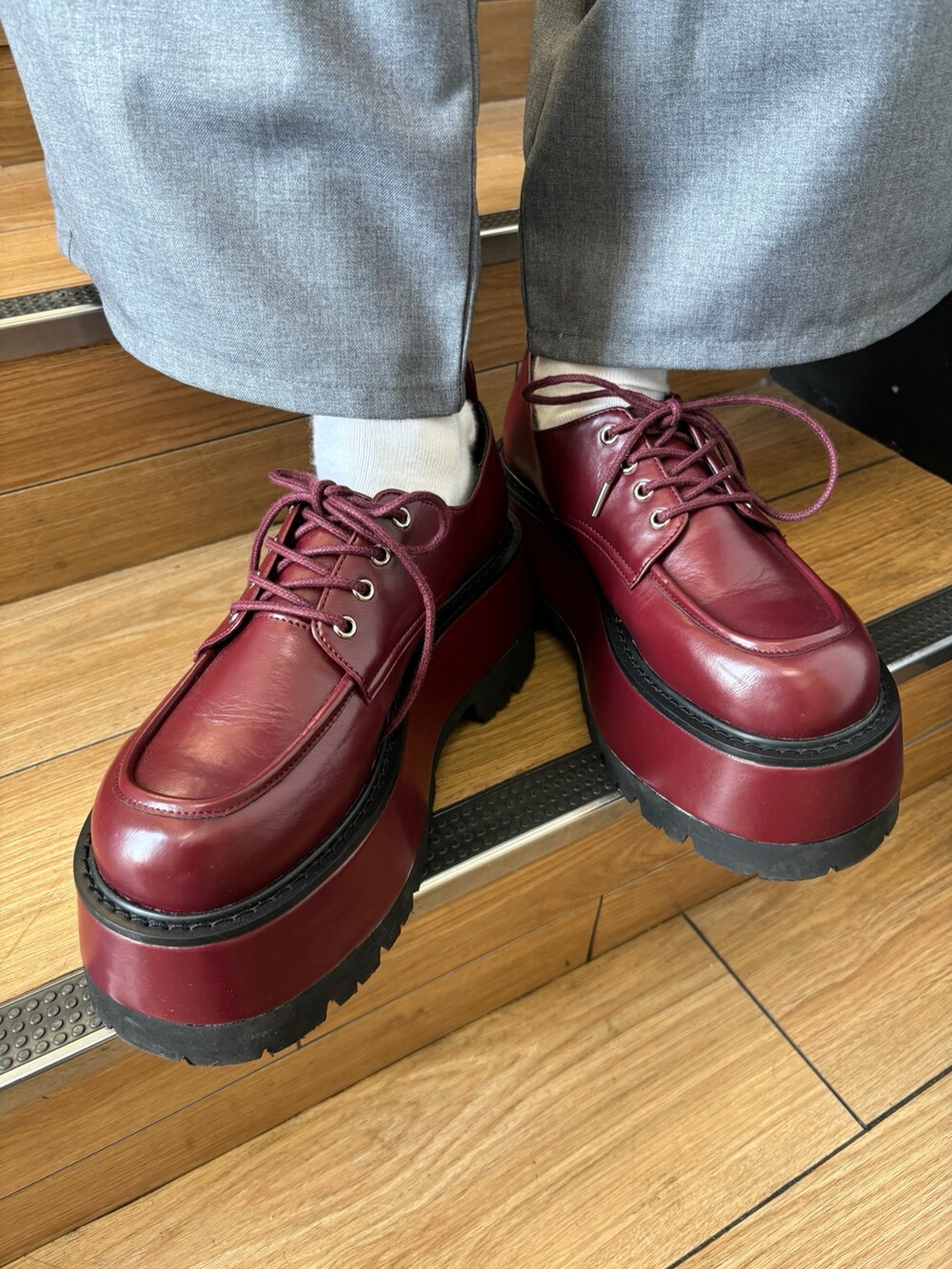 レッド系のハンドバッグ、レッド系のドレスシューズ、グレー系のテーラードジャケットを着用したレディースの夏コーディネートの10枚目の写真