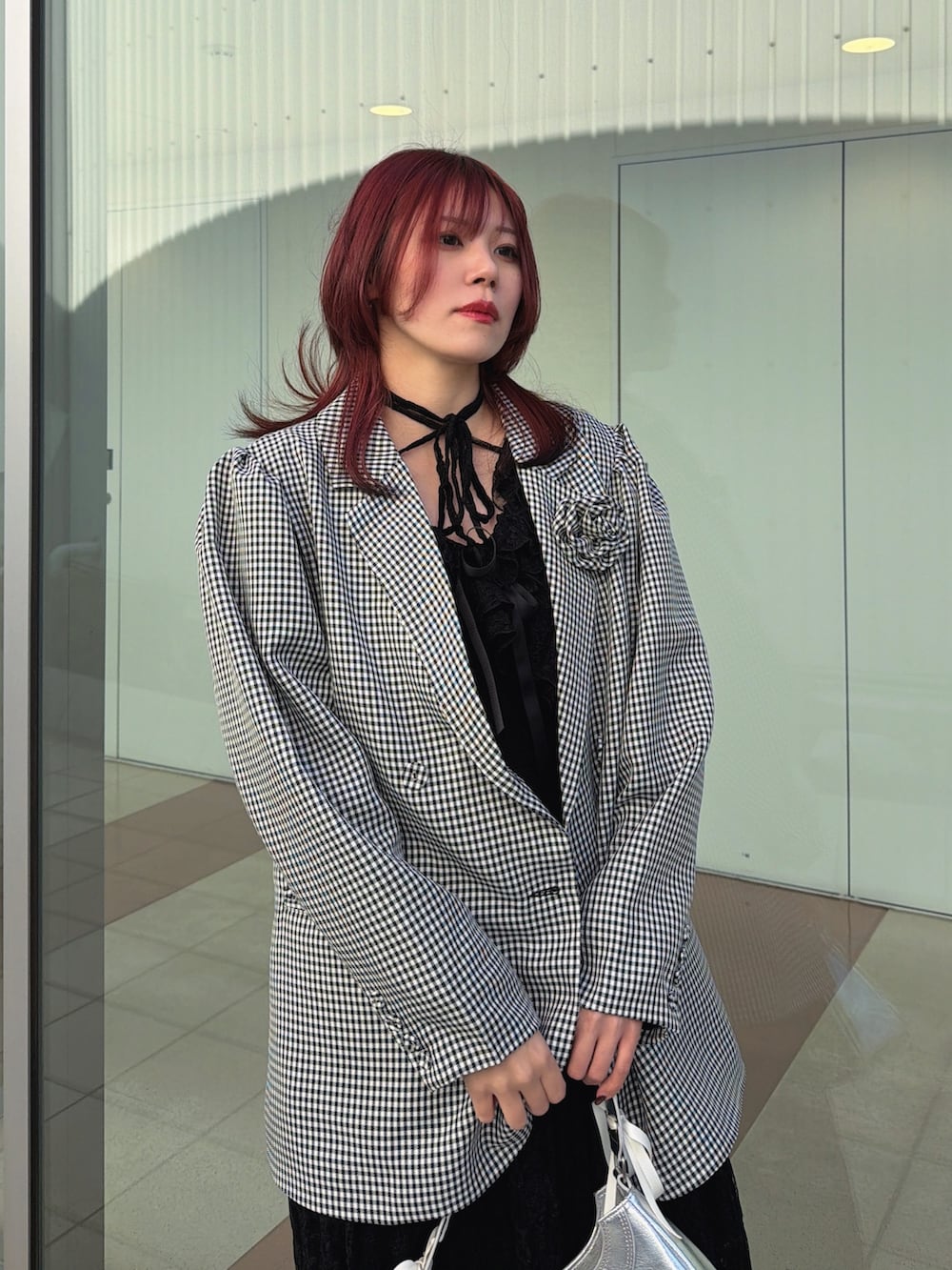 ブラック系のワンピース、ブラック系のテーラードジャケット、シルバー系のハンドバッグを着用したレディースの冬コーディネートの5枚目の写真