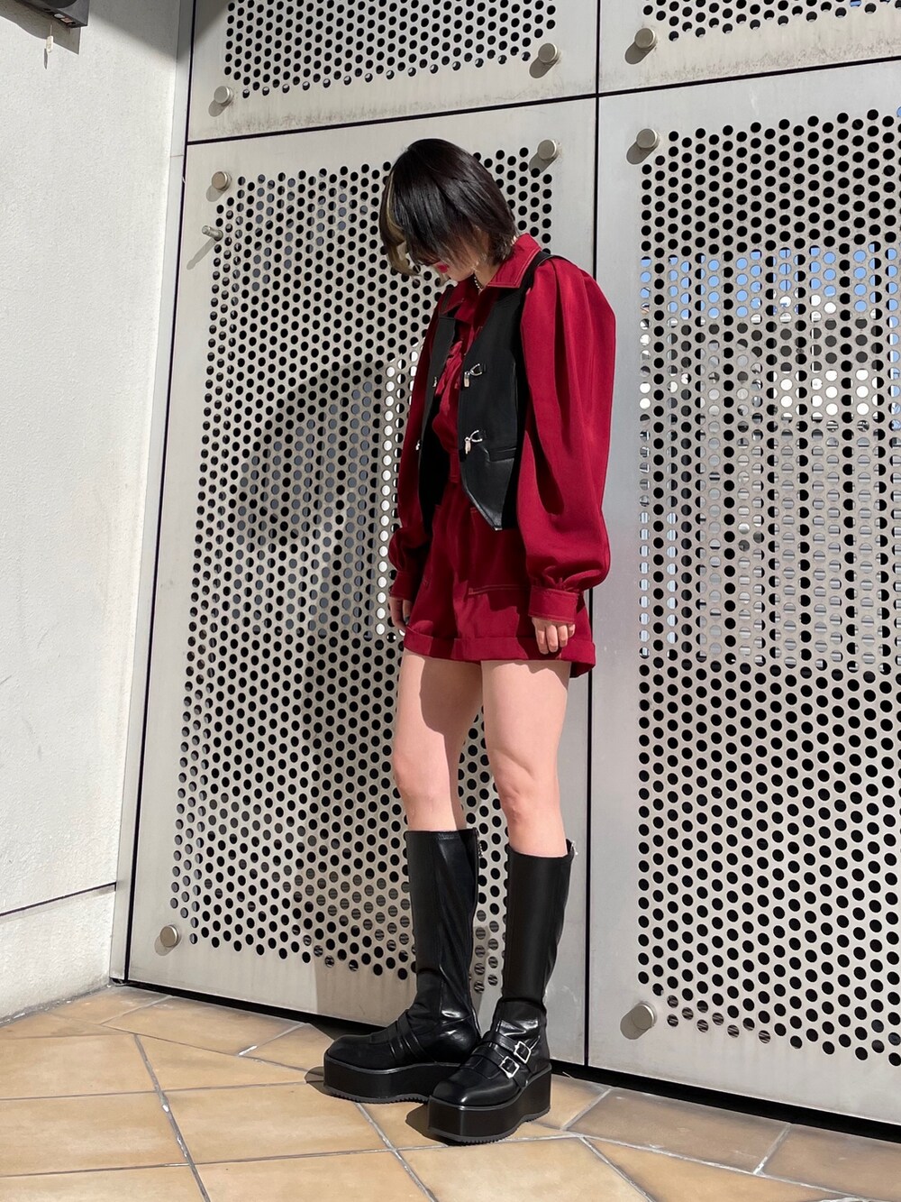 ブラック系のブーツ、ブラック系のベスト、レッド系のつなぎ/オールインワンを着用したレディースの春コーディネートの2枚目の写真