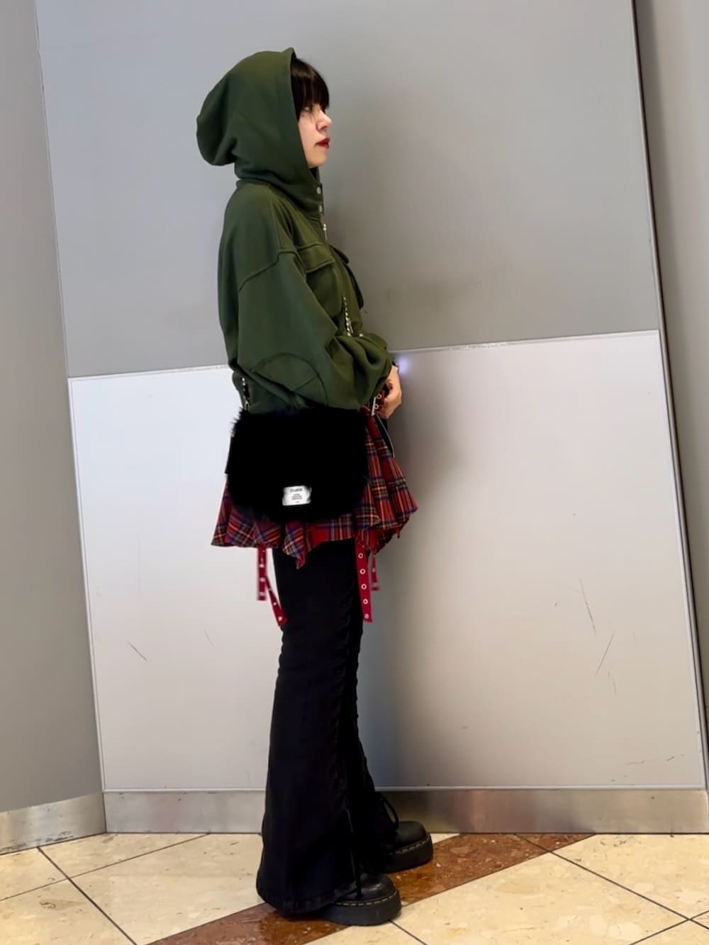 ブラック系のハンドバッグ、ブラック系のデニムパンツ、グリーン系のパーカーを着用したレディースの秋コーディネートの4枚目の写真