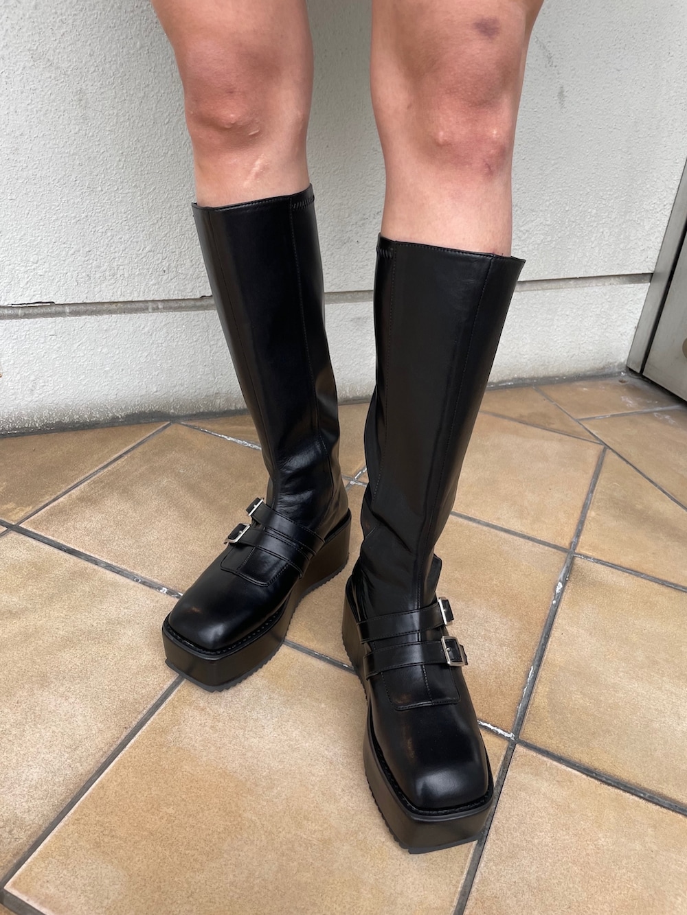 ブラック系のデニムパンツ、ブラック系のブーツ、ブルー系のTシャツ/カットソーを着用したレディースの冬コーディネートの9枚目の写真