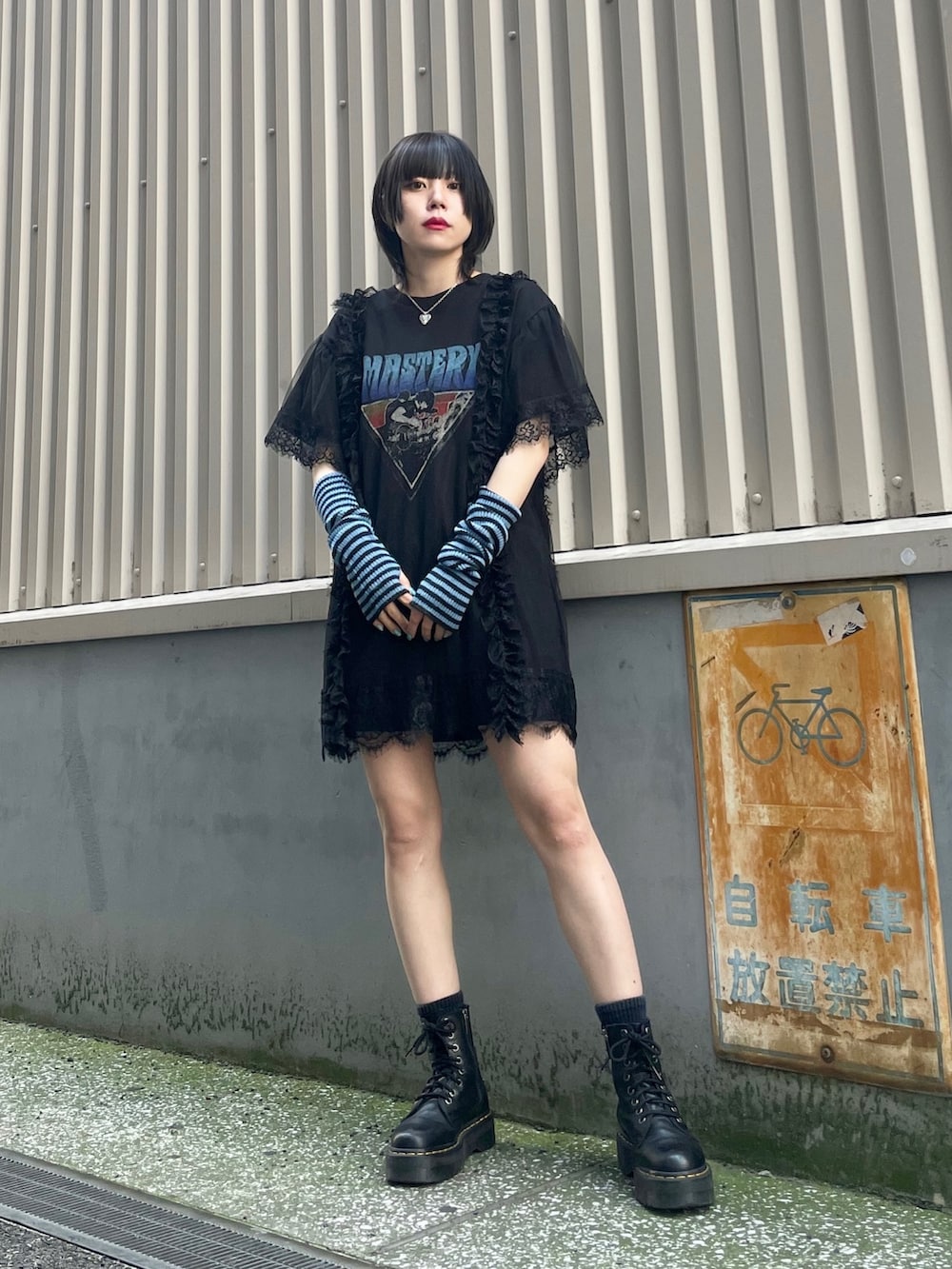 ブラック系のワンピース、ブルー系のアームカバー、シルバー系のネックレスを着用したレディースの春コーディネートの3枚目の写真