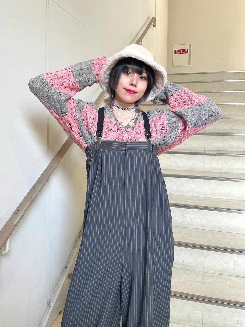 グレー系のつなぎ/オールインワン、ホワイト系のスニーカー、ベージュ系のTシャツ/カットソーを着用したレディースの冬コーディネートの6枚目の写真