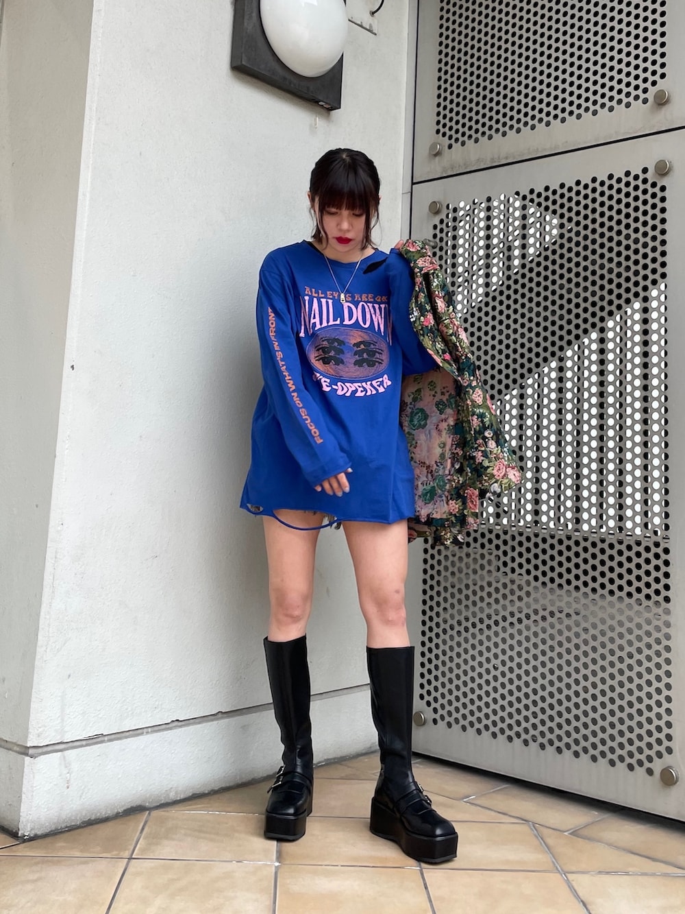 ブラック系のデニムパンツ、ブラック系のブーツ、ブルー系のTシャツ/カットソーを着用したレディースの冬コーディネートの3枚目の写真