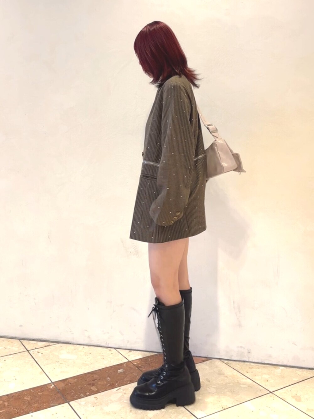 ブラック系のブーツ、ピンク系のショルダーバッグ、グレー系のテーラードジャケットを着用したレディースの秋コーディネートの3枚目の写真