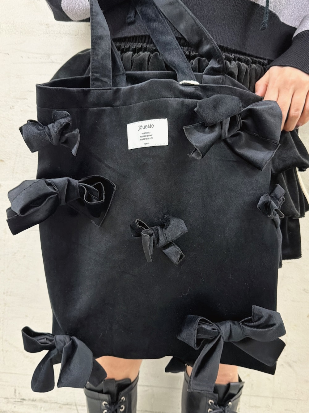 ブラック系のスカート、その他のニット/セーター、ブラック系のブーツを着用したレディースの秋コーディネートの8枚目の写真