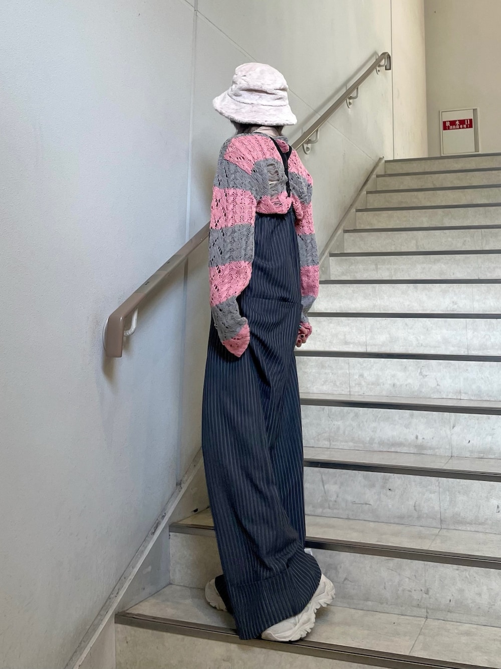 グレー系のつなぎ/オールインワン、ホワイト系のスニーカー、ベージュ系のTシャツ/カットソーを着用したレディースの冬コーディネートの4枚目の写真