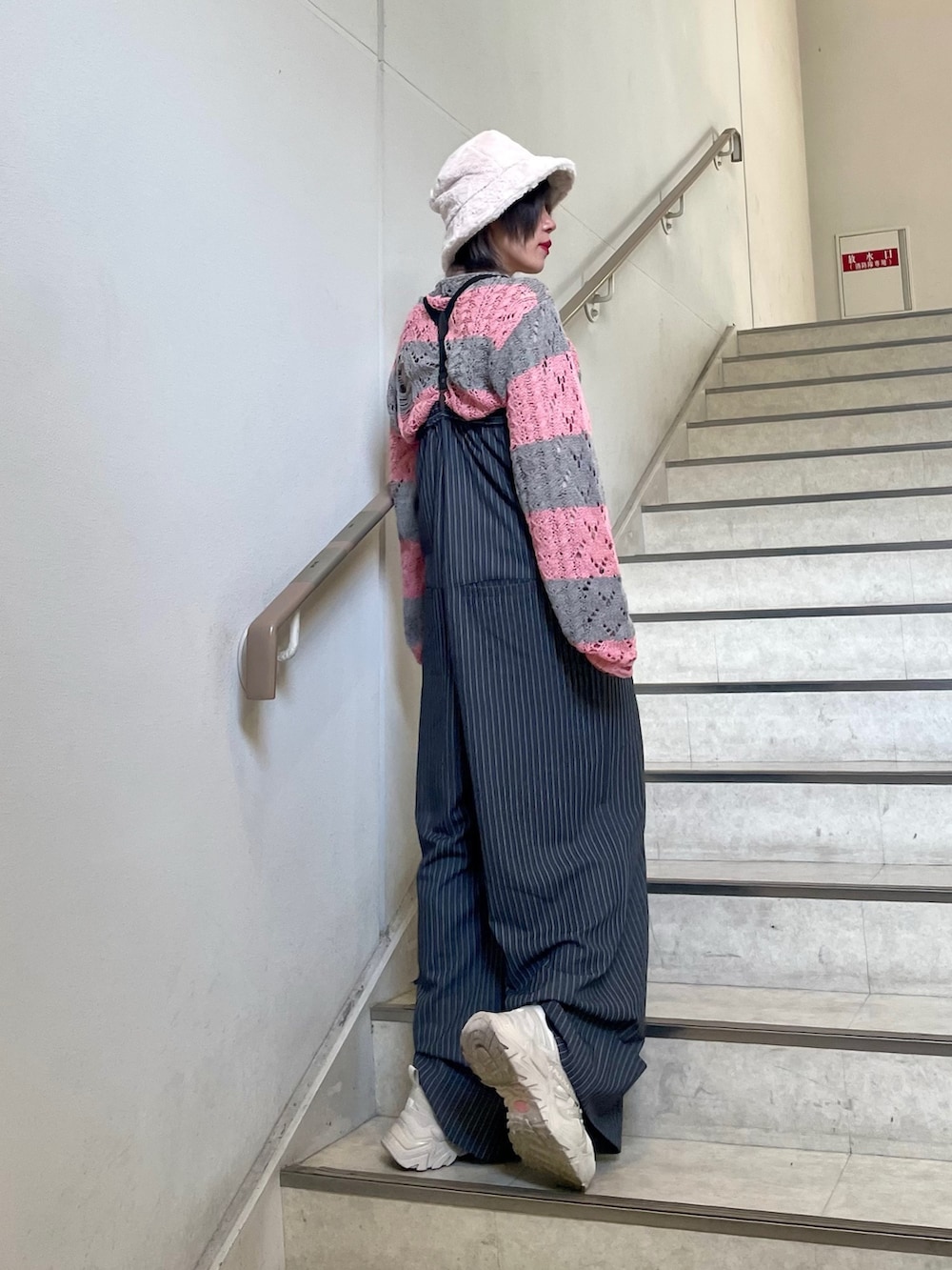 グレー系のつなぎ/オールインワン、ホワイト系のスニーカー、ベージュ系のTシャツ/カットソーを着用したレディースの冬コーディネートの3枚目の写真