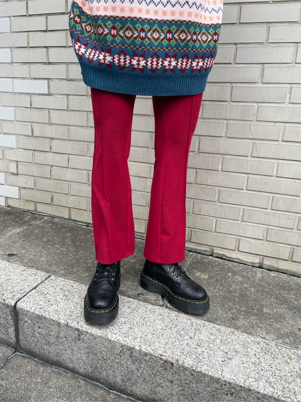 ブルー系のニット/セーター、レッド系のその他パンツ、シルバー系のネックレスを着用したレディースの秋コーディネートの7枚目の写真