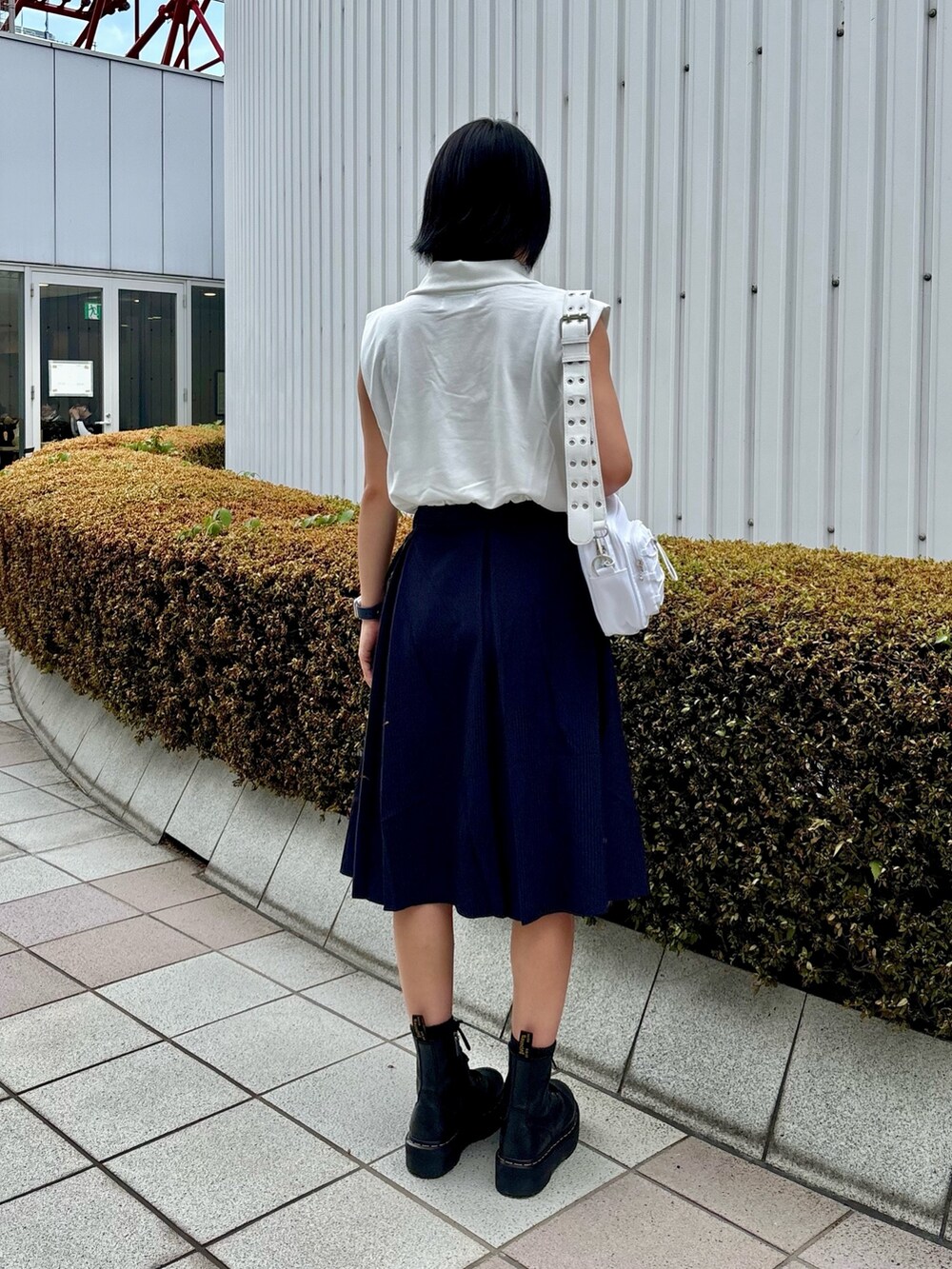 ブルー系のスカート、ホワイト系のショルダーバッグ、ホワイト系のTシャツ/カットソーを着用したレディースの夏コーディネートの3枚目の写真