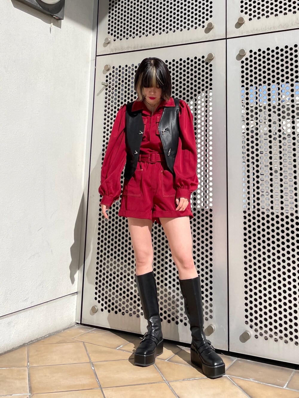 ブラック系のブーツ、ブラック系のベスト、レッド系のつなぎ/オールインワンを着用したレディースの春コーディネートの3枚目の写真