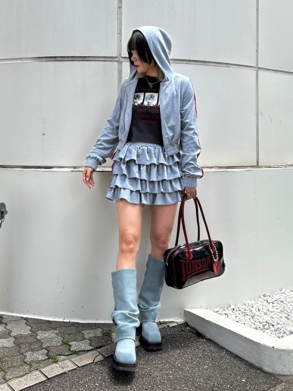 ブラック系のボストンバッグ、ブルー系のブーツ、ブラック系のTシャツ/カットソーを着用したレディースの春コーディネートの2枚目の写真