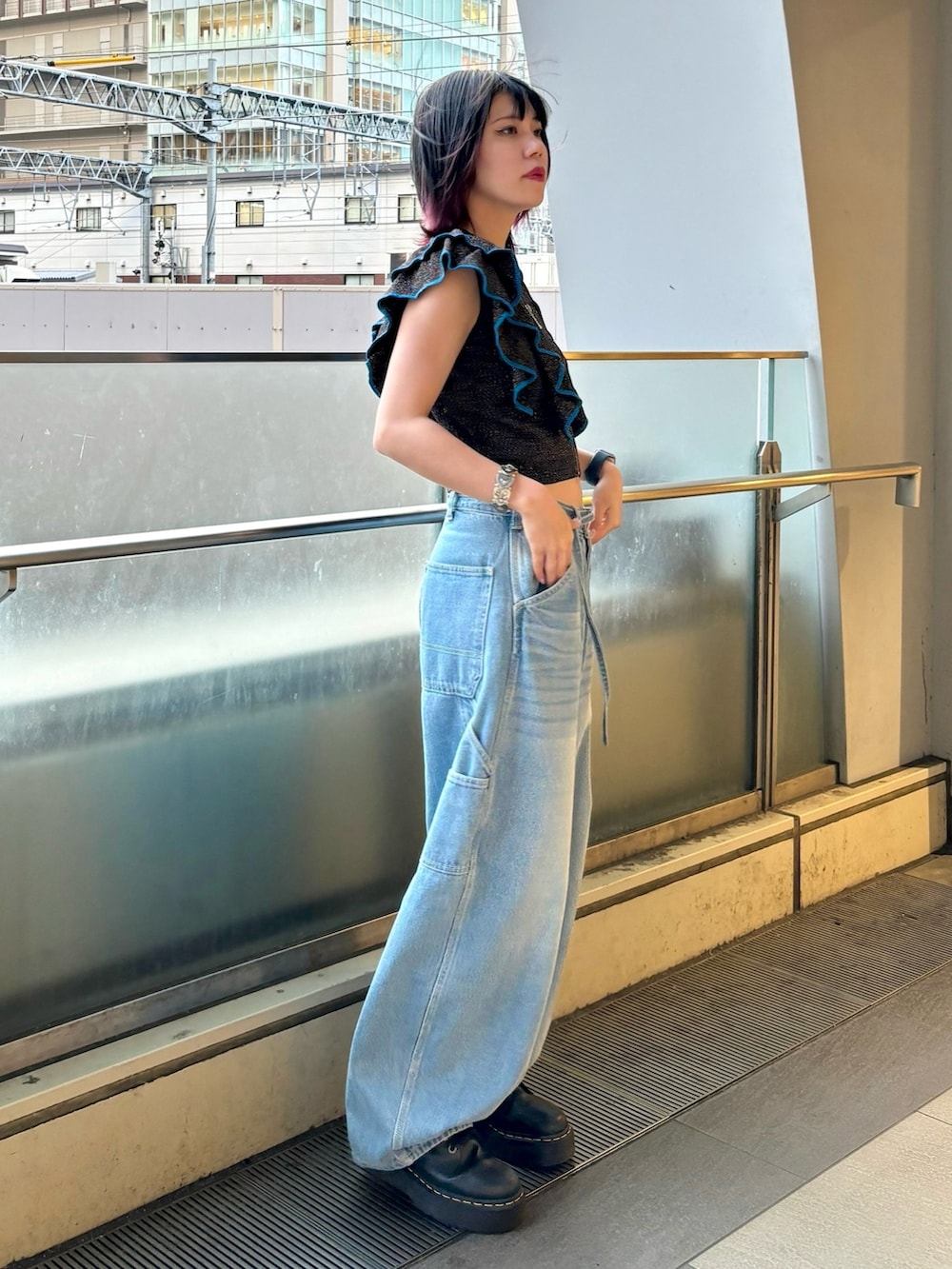 ブルー系のデニムパンツ、ブラック系のニット/セーター、シルバー系のブレスレットを着用したレディースの夏コーディネートの2枚目の写真