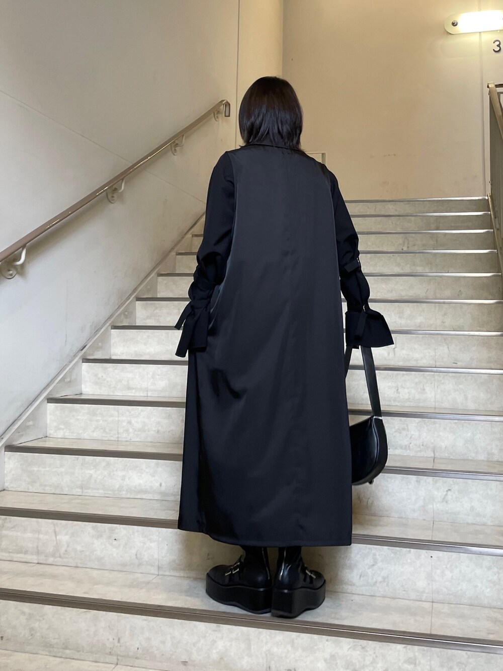 ブラック系のブーツ、ブラック系のシャツ/ブラウス、ブラック系のショルダーバッグを着用したレディースの春コーディネートの6枚目の写真