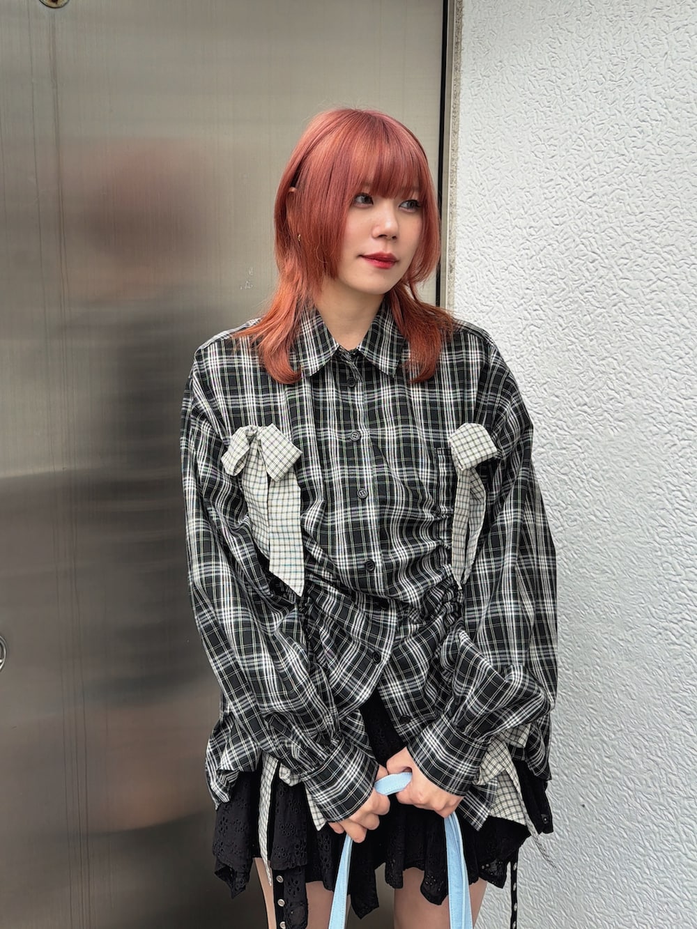 ブラック系のシャツ/ブラウス、ブルー系のトートバッグ、ブラック系のブーツを着用したレディースの冬コーディネートの6枚目の写真