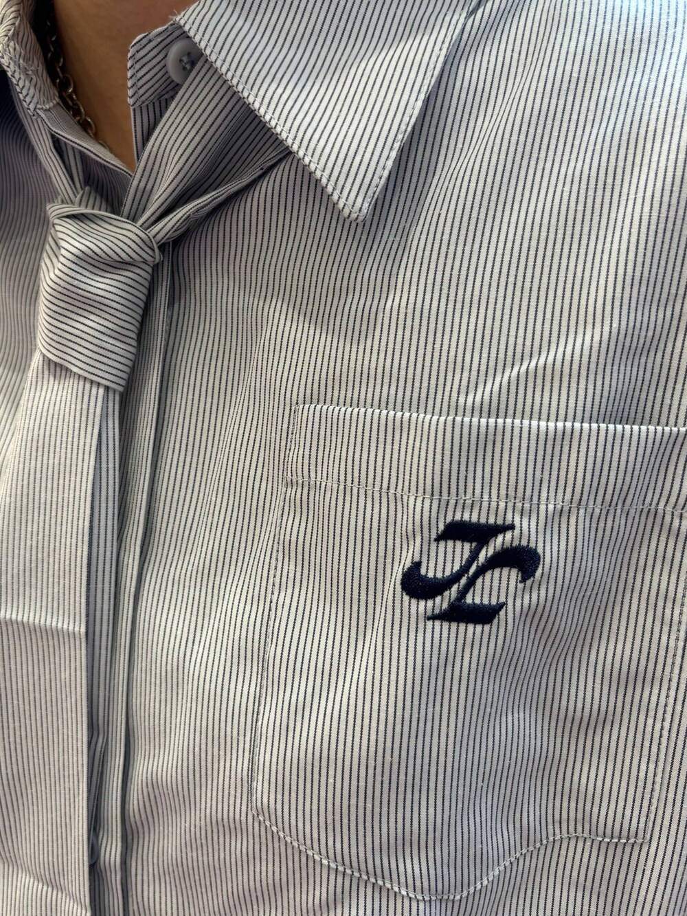 ブルー系のシャツ/ブラウス、ホワイト系のショルダーバッグ、ブラック系のデニムパンツを着用したレディースの夏コーディネートの7枚目の写真