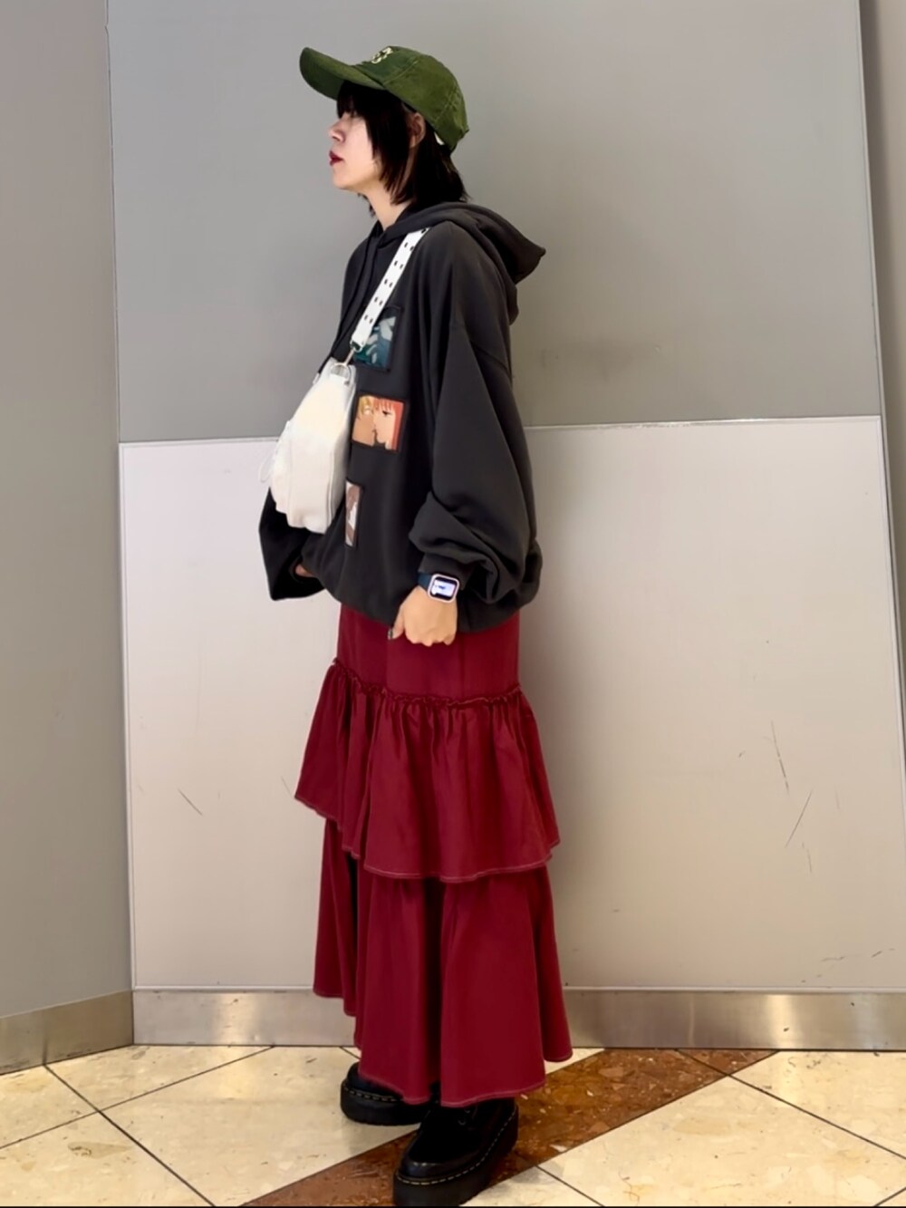 レッド系のワンピース、グレー系のパーカー、ホワイト系のショルダーバッグを着用したレディースの秋コーディネートの5枚目の写真