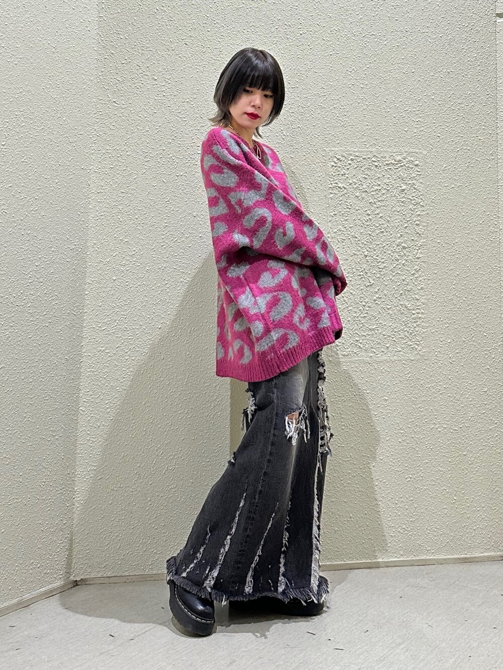 ピンク系のニット/セーター、ブラック系のデニムスカートを着用したレディースの冬コーディネートの3枚目の写真