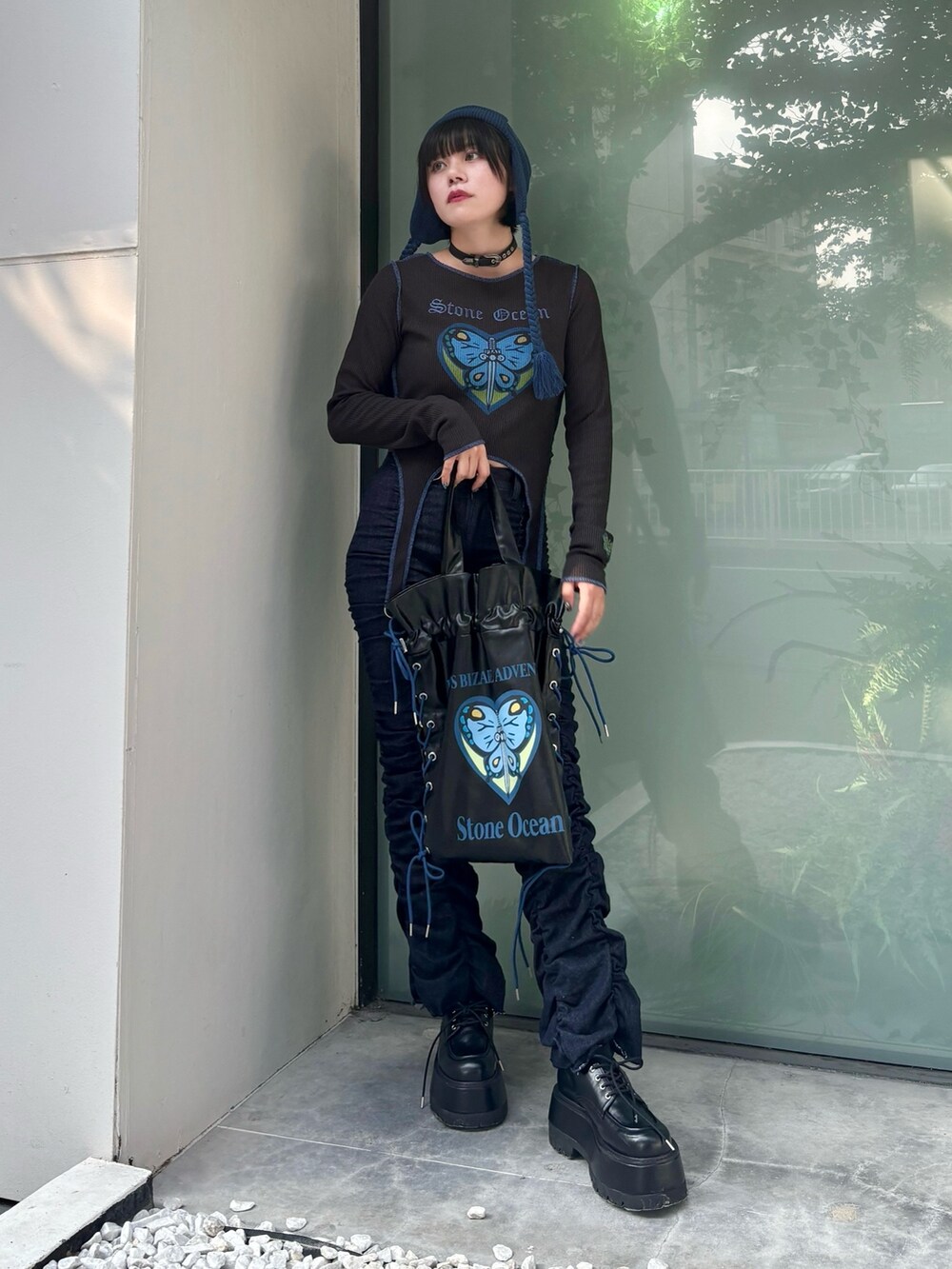 ブラック系のトートバッグ、ブルー系のデニムパンツ、ブラック系のTシャツ/カットソーを着用したレディースの秋コーディネートの2枚目の写真