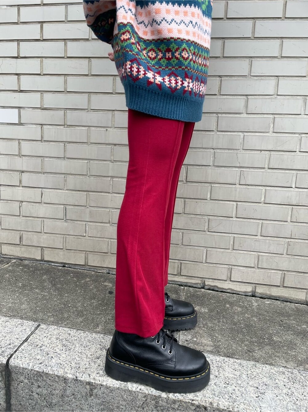 ブルー系のニット/セーター、レッド系のその他パンツ、シルバー系のネックレスを着用したレディースの秋コーディネートの6枚目の写真