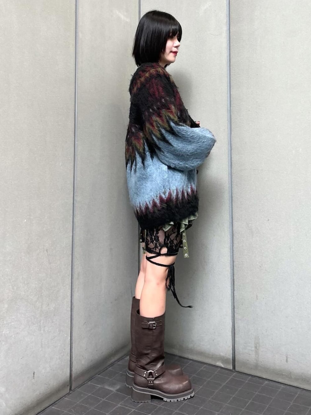 ブラック系のTシャツ/カットソー、ブラック系のカーディガン/ボレロ、グリーン系のスカートを着用したレディースの秋コーディネートの4枚目の写真