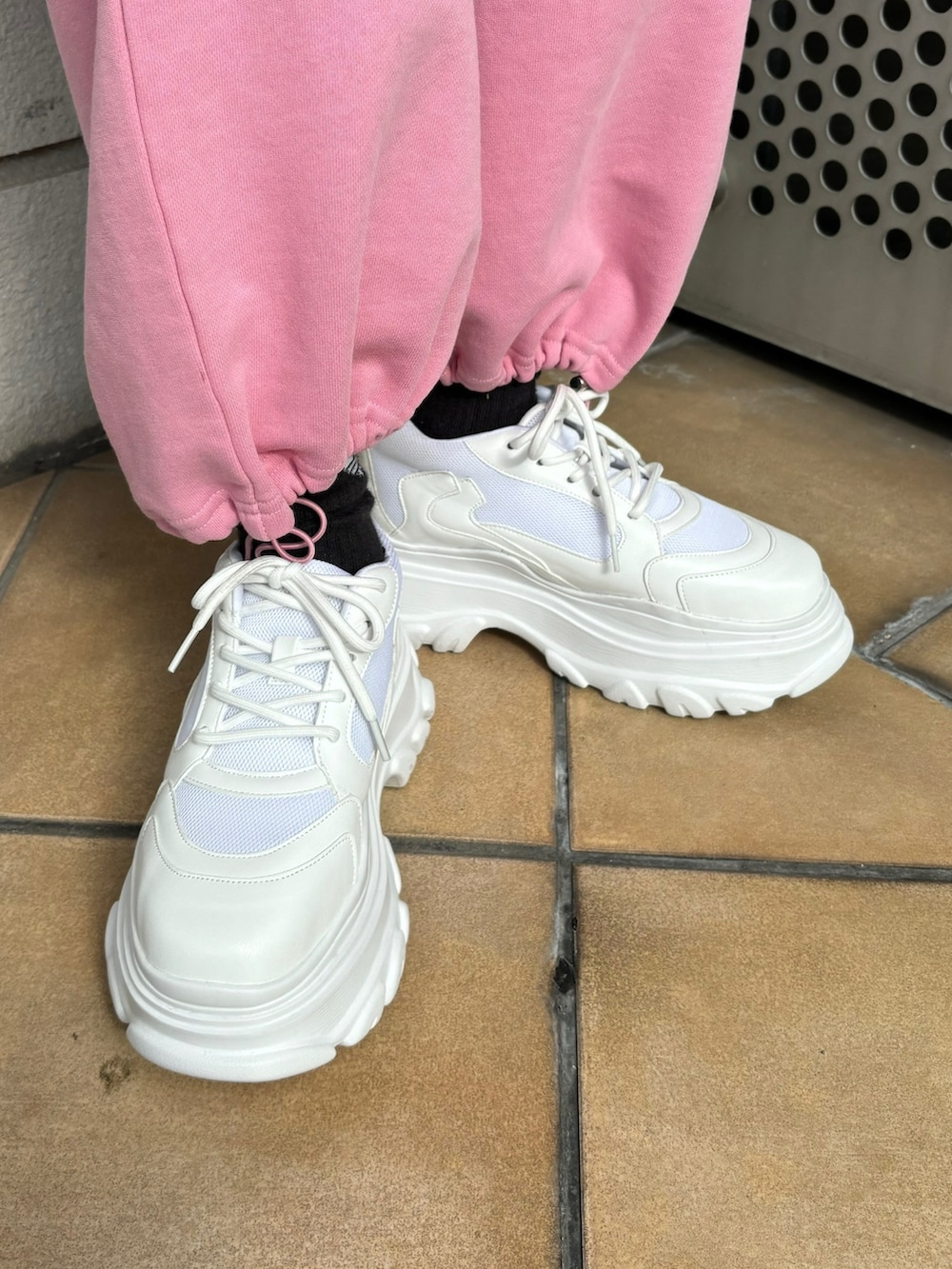 ホワイト系のスニーカー、ピンク系のスウェットパンツ、ブルー系のライダースジャケットを着用したレディースの春コーディネートの10枚目の写真