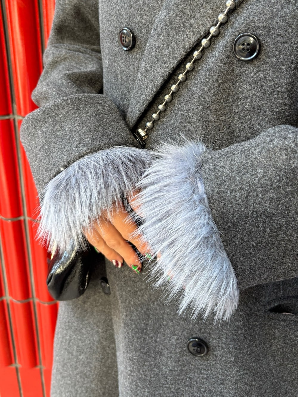 グレー系のチェスターコート、ブラック系のブーツ、ブラック系のハンドバッグを着用したレディースの冬コーディネートの6枚目の写真