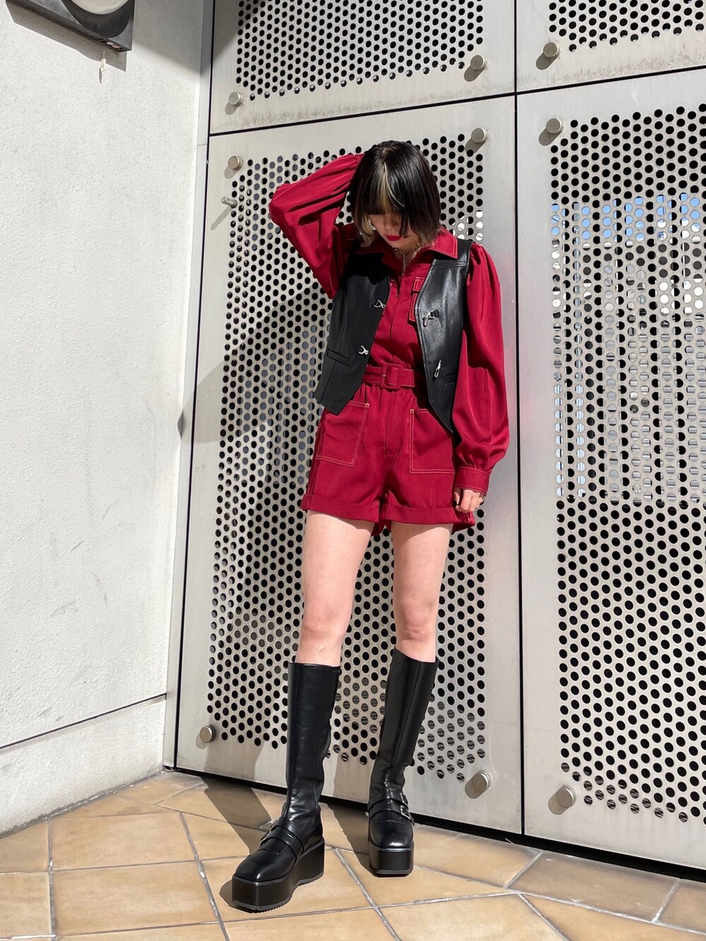 ブラック系のブーツ、ブラック系のベスト、レッド系のつなぎ/オールインワンを着用したレディースの春コーディネートの5枚目の写真