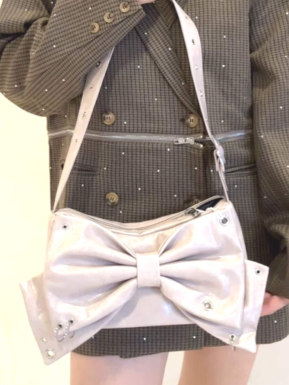 ブラック系のブーツ、ピンク系のショルダーバッグ、グレー系のテーラードジャケットを着用したレディースの秋コーディネートの7枚目の写真