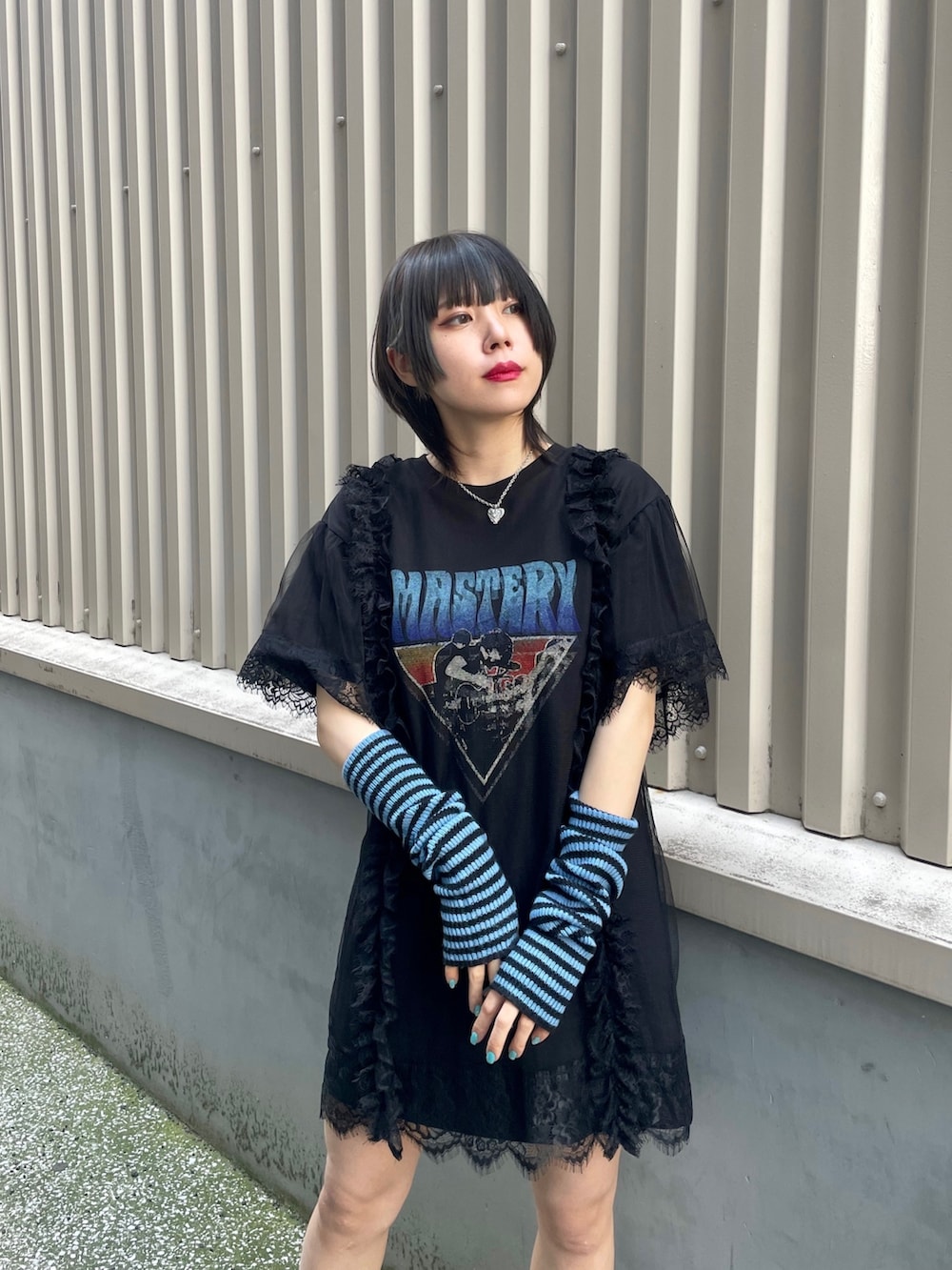 ブラック系のワンピース、ブルー系のアームカバー、シルバー系のネックレスを着用したレディースの春コーディネートの6枚目の写真