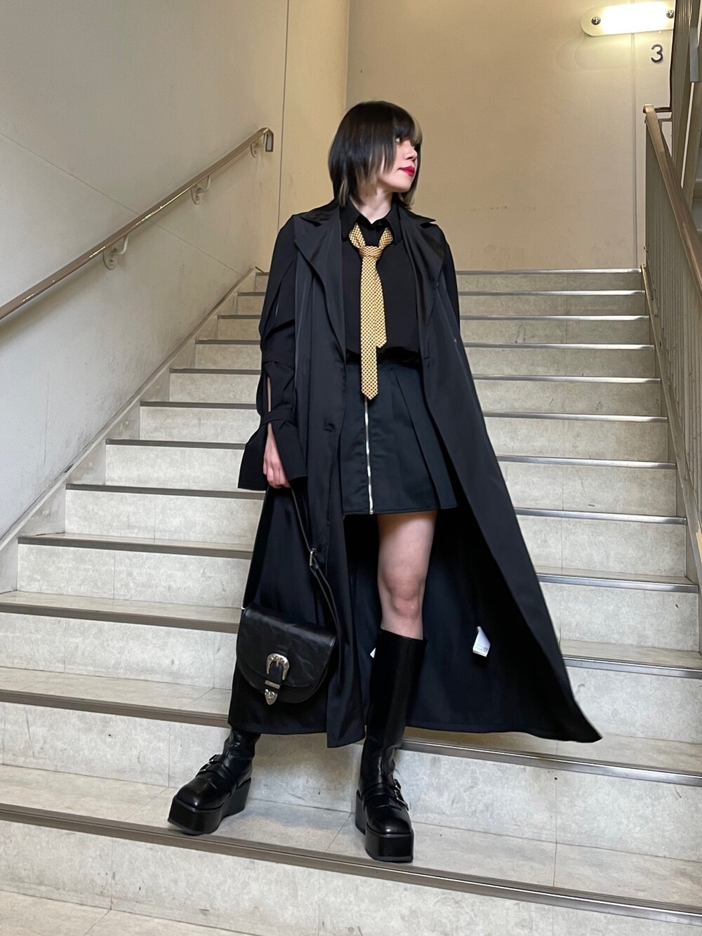 ブラック系のブーツ、ブラック系のシャツ/ブラウス、ブラック系のショルダーバッグを着用したレディースの春コーディネートの4枚目の写真