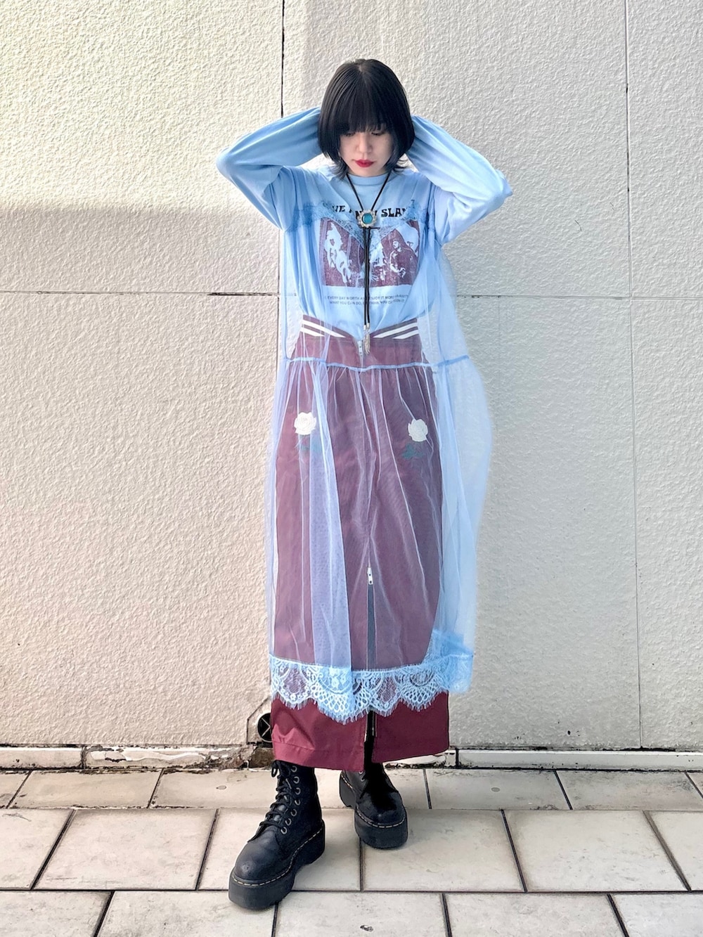 レッド系のスカート、ブルー系のワンピースを着用したレディースの冬コーディネートの2枚目の写真