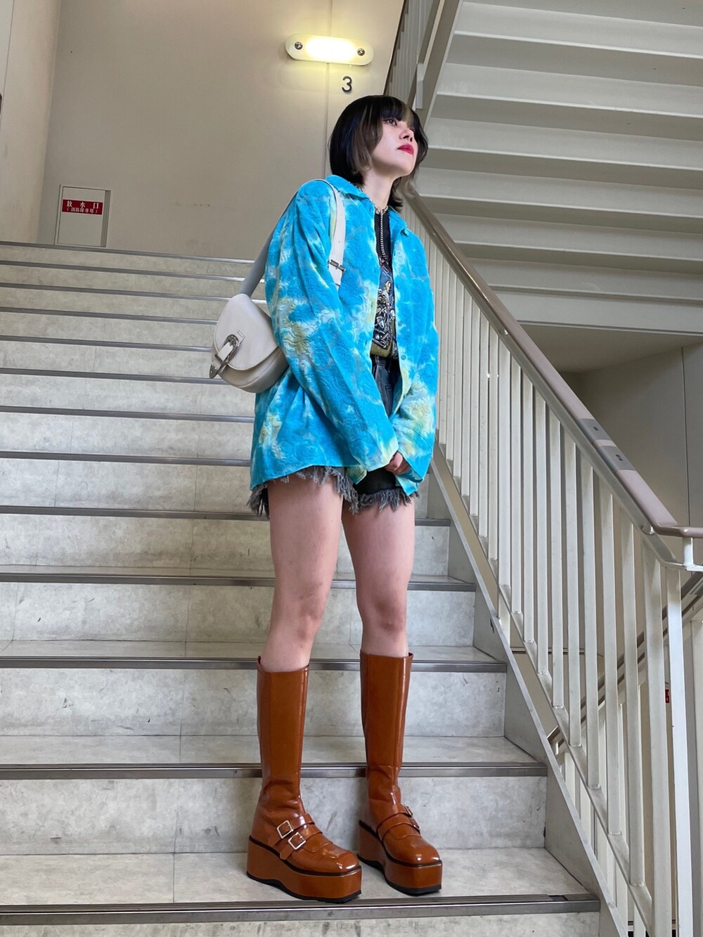 ブラック系のデニムパンツ、ブルー系のシャツ/ブラウス、ブラック系のTシャツ/カットソーを着用したレディースの春コーディネートの5枚目の写真
