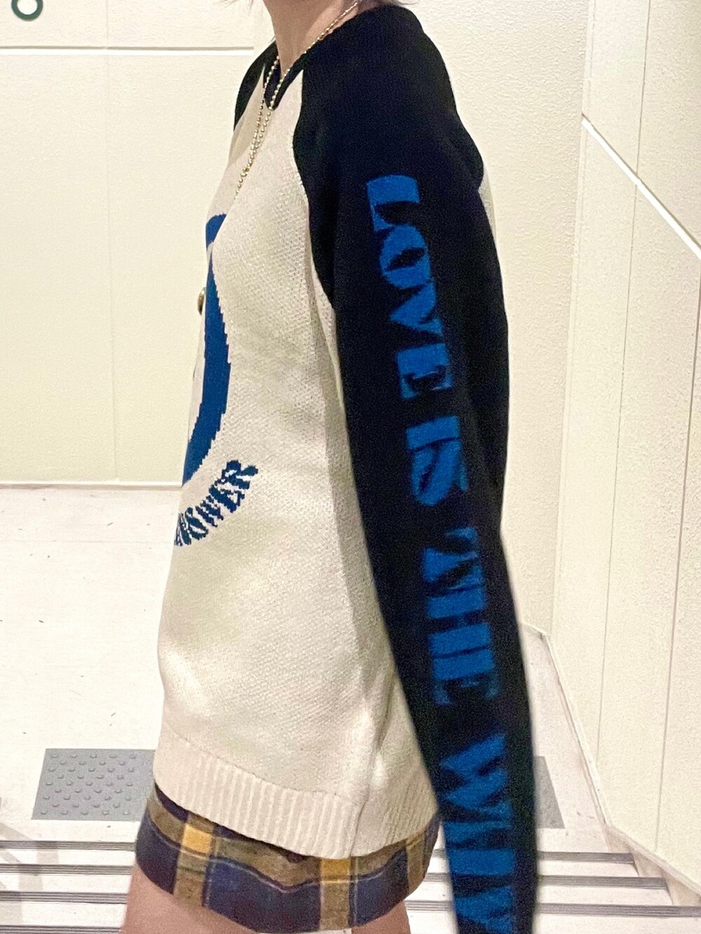 ブラック系のその他アウター、イエロー系のスカート、ホワイト系のブーツを着用したレディースの秋コーディネートの9枚目の写真