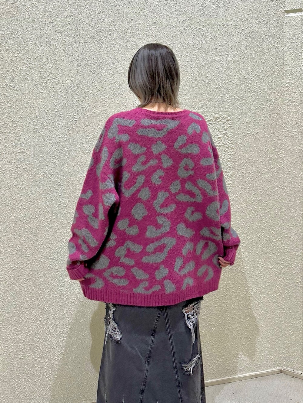 ピンク系のニット/セーター、ブラック系のデニムスカートを着用したレディースの冬コーディネートの6枚目の写真