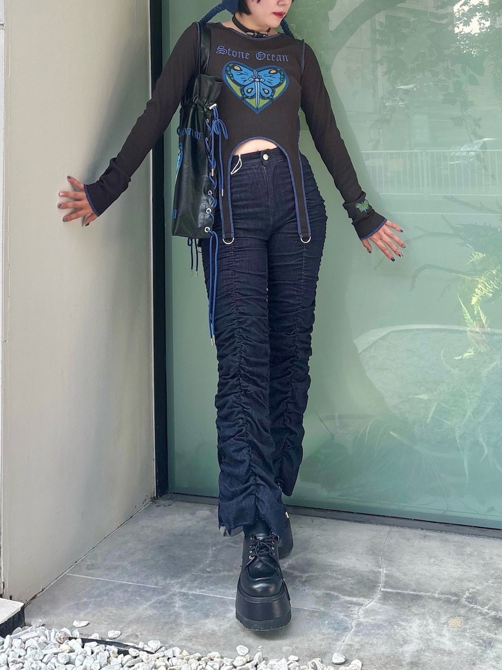 ブラック系のトートバッグ、ブルー系のデニムパンツ、ブラック系のTシャツ/カットソーを着用したレディースの秋コーディネートの5枚目の写真