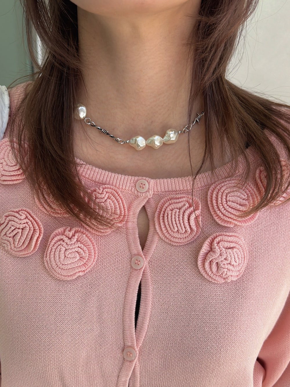 ピンク系のニット/セーター、ホワイト系のトートバッグ、ブルー系のデニムパンツを着用したレディースの春コーディネートの10枚目の写真