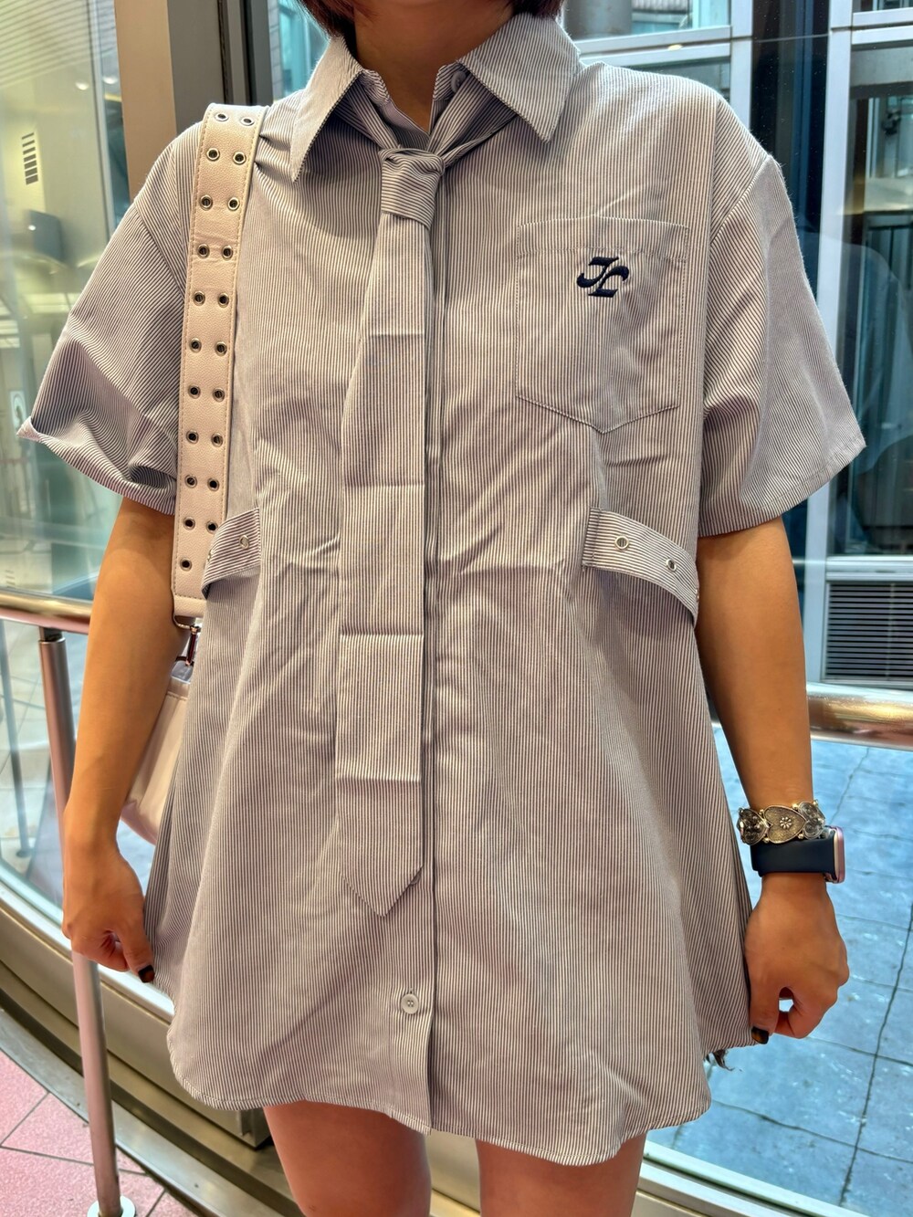 ブルー系のシャツ/ブラウス、ホワイト系のショルダーバッグ、ブラック系のデニムパンツを着用したレディースの夏コーディネートの6枚目の写真