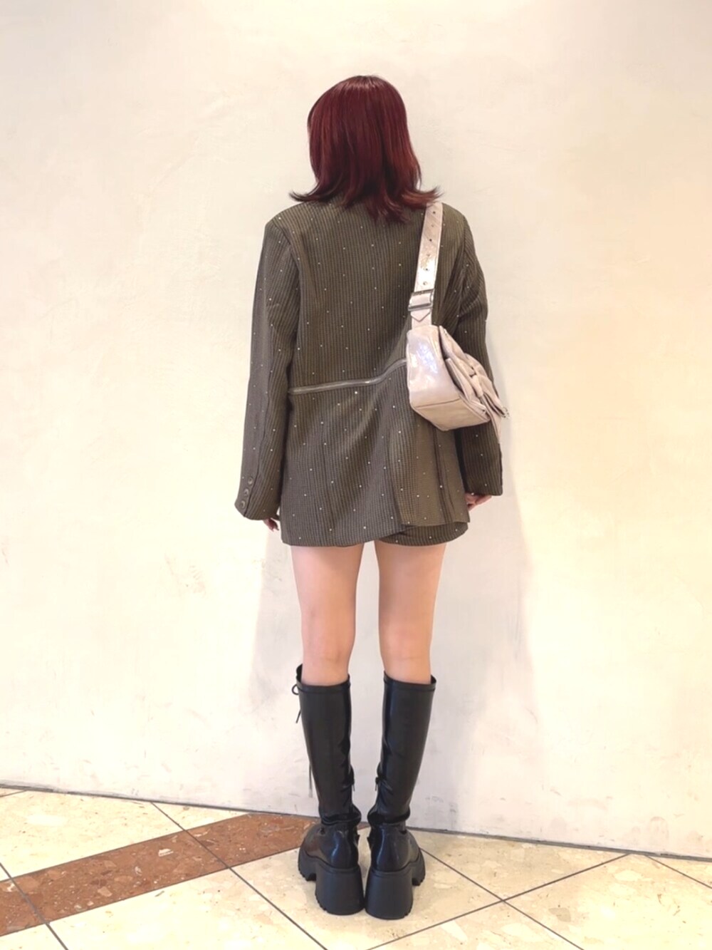 ブラック系のブーツ、ピンク系のショルダーバッグ、グレー系のテーラードジャケットを着用したレディースの秋コーディネートの4枚目の写真