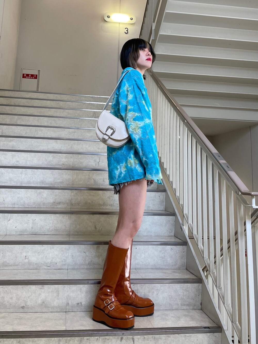 ブラック系のデニムパンツ、ブルー系のシャツ/ブラウス、ブラック系のTシャツ/カットソーを着用したレディースの春コーディネートの6枚目の写真